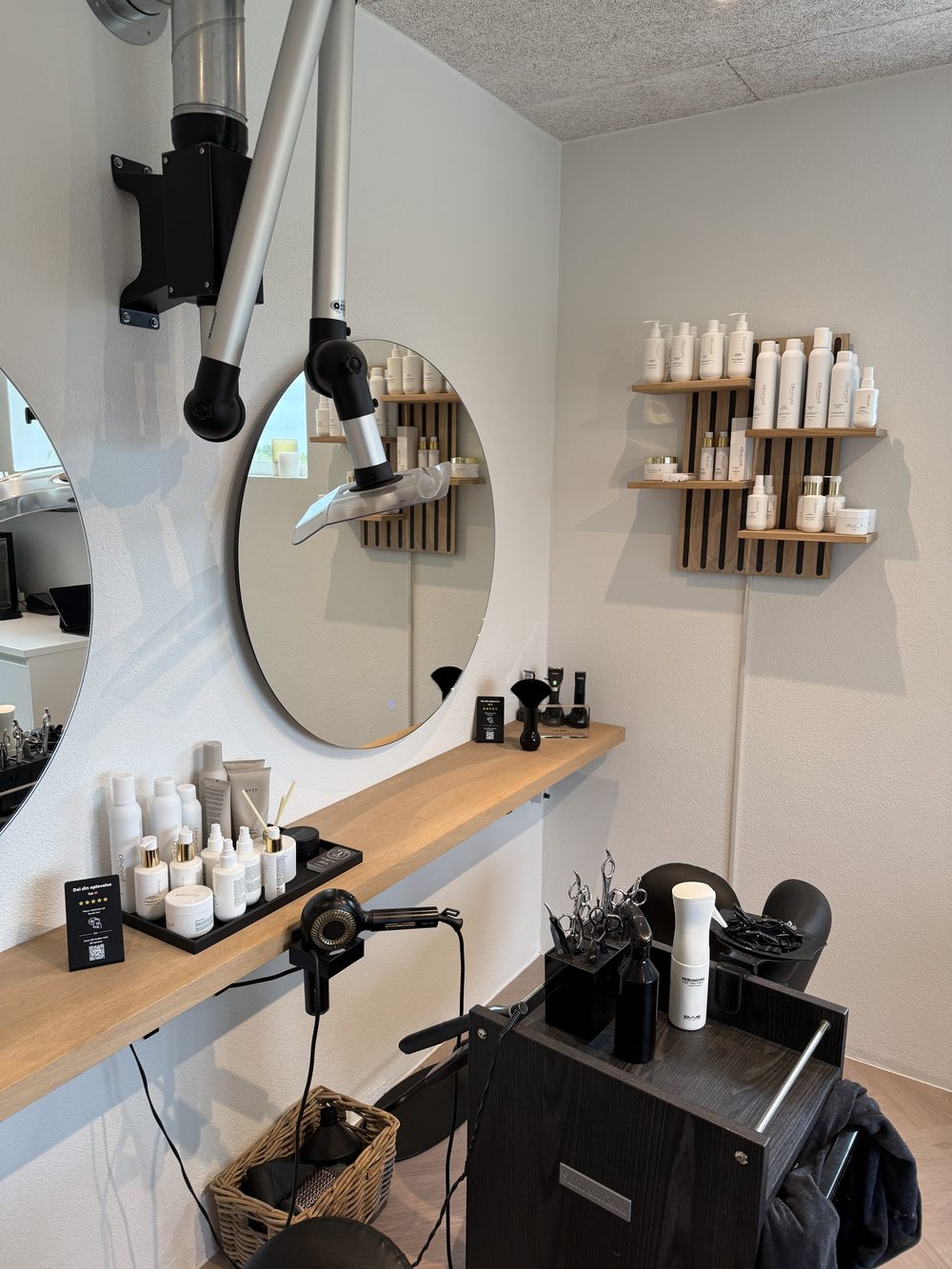 Rundt spejl med styling-redskaber og produkthylde